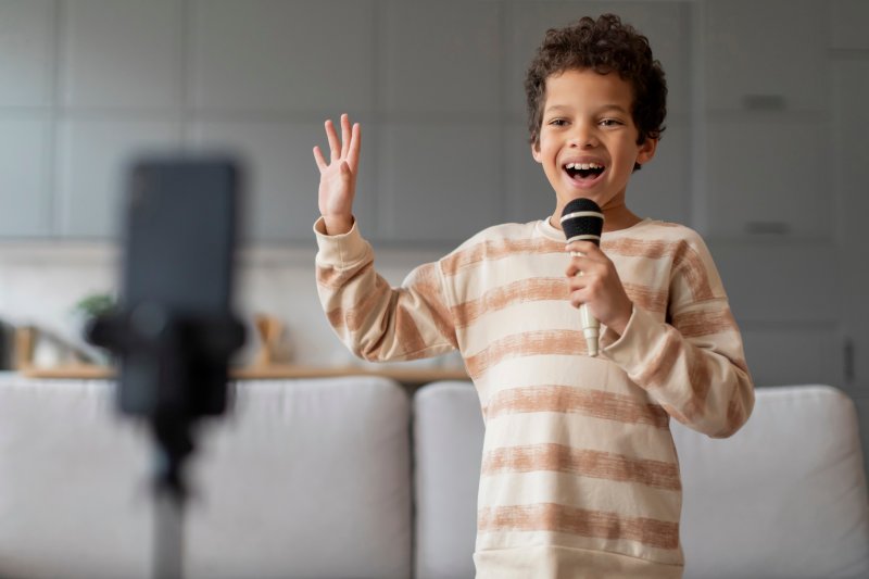 little boy holding a microphone and singing